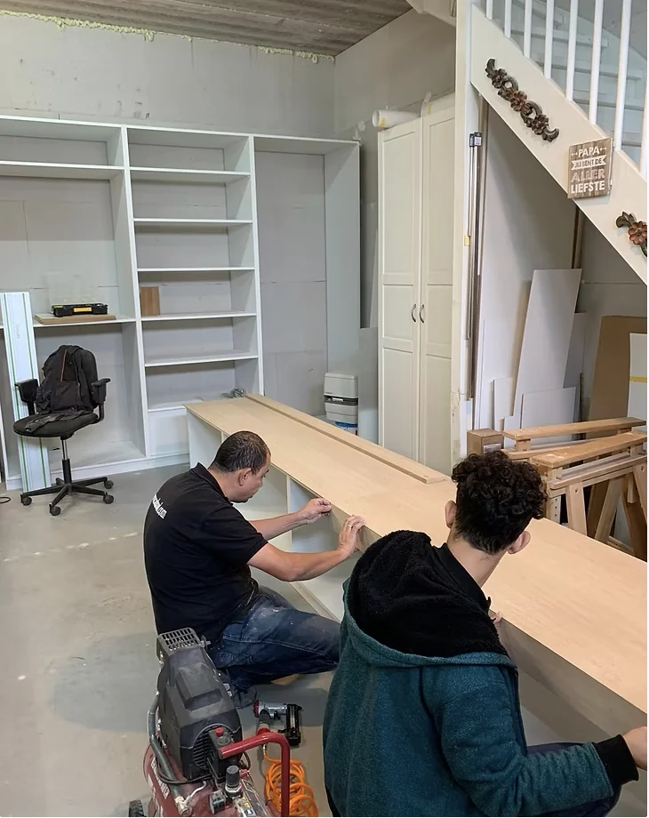 Vader en zoon maken samen een meubel in de werkplaats